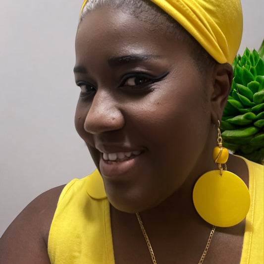 Model wearing vibrant yellow wood earrings with a matching ethnic headwrap