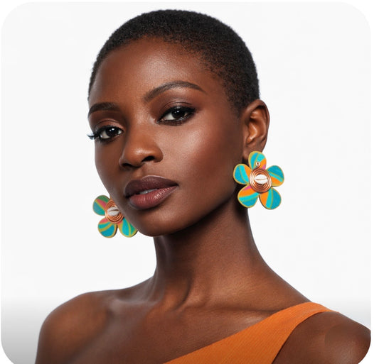 Beautiful dark skin woman with very short natural hair wearing colorful Afrocentric cowrie shell statement earrings on a clean white background