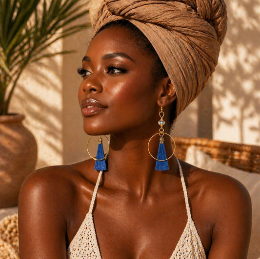 Afrocentric grey bone and gold hoop earrings on a dark skin woman wearing a headwrap highlighting cultural style and elegance