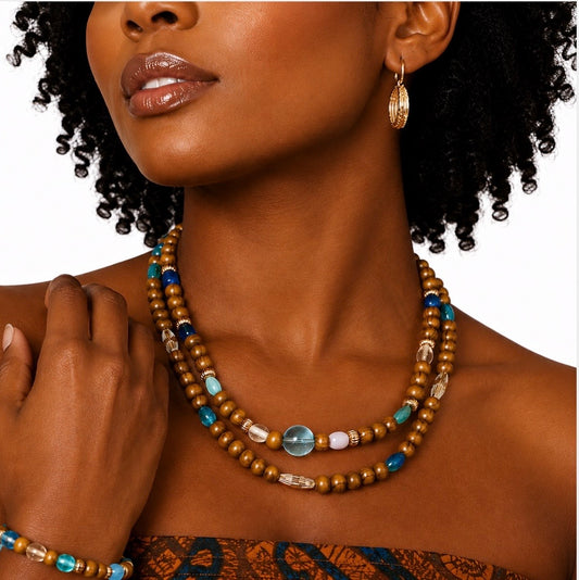 Close-up of handmade Afrocentric turquoise earth harmony necklace set on model showing brown wood beads, turquoise glass beads, and gold accent details.