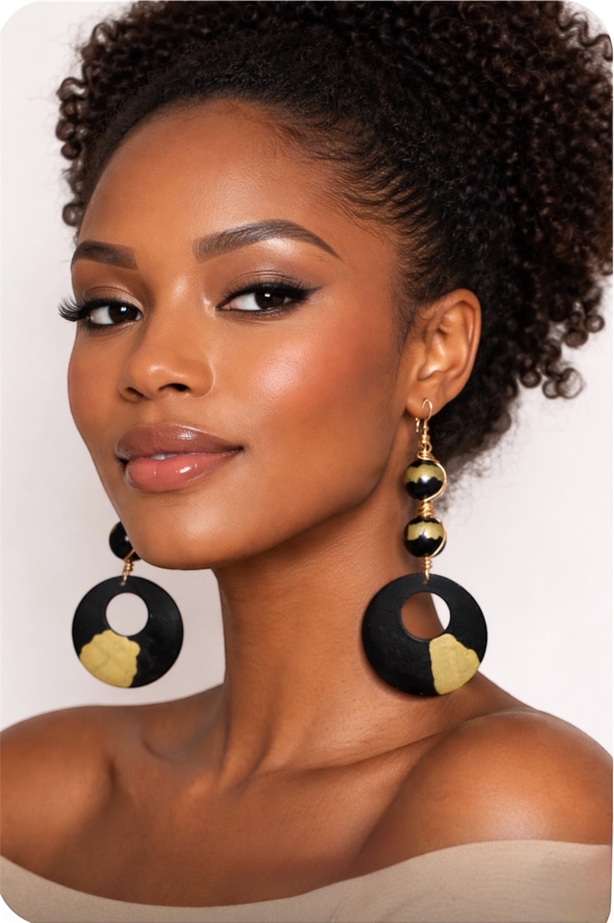 afrocentric black and gold statement earrings on dark skin woman close up portrait natural beauty elegant style