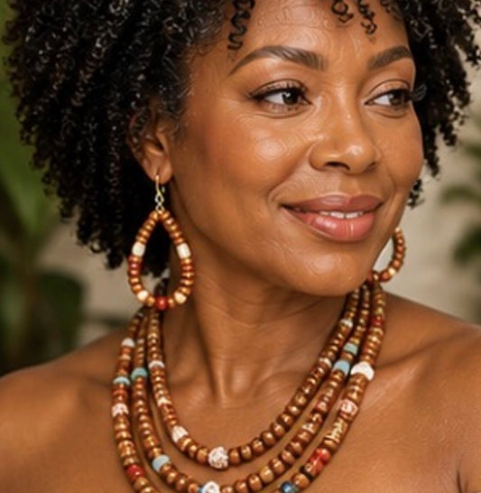 Afrocentric Earth Harmony handmade beaded necklace and earring set worn by middle aged woman with natural kinky hair