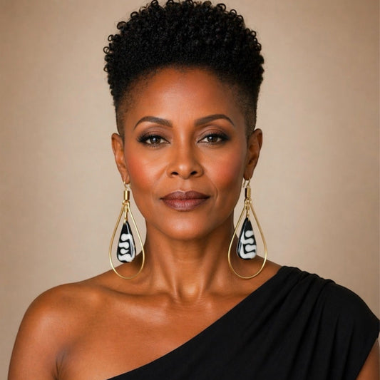 Afrocentric gold teardrop earrings with carved bone drop worn by elegant Black woman facing forward