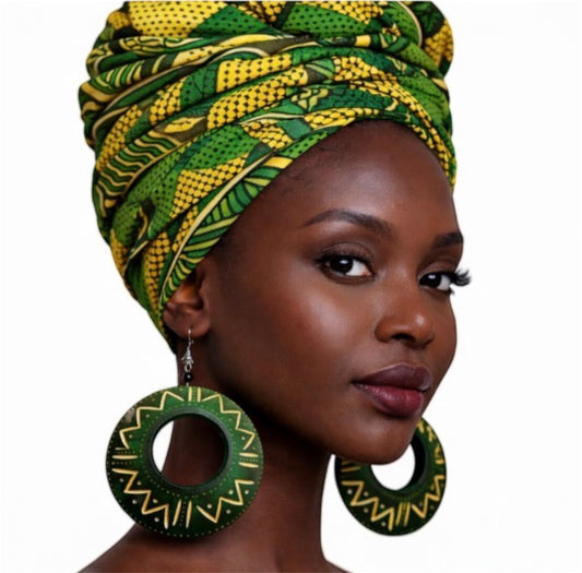 Close up of beautiful dark skin woman wearing afrocentric green calabash statement earrings with gold tribal patterns and vibrant african print headwrap bold handmade jewelry