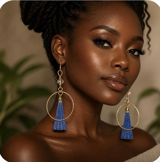 Afrocentric grey bone and gold hoop statement earrings worn by a dark skin woman in a forward facing lifestyle image showing detail and elegance