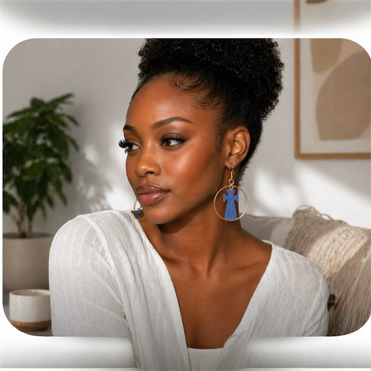 Black woman wearing afrocentric grey cross hoop earrings indoors styled for everyday elegant look