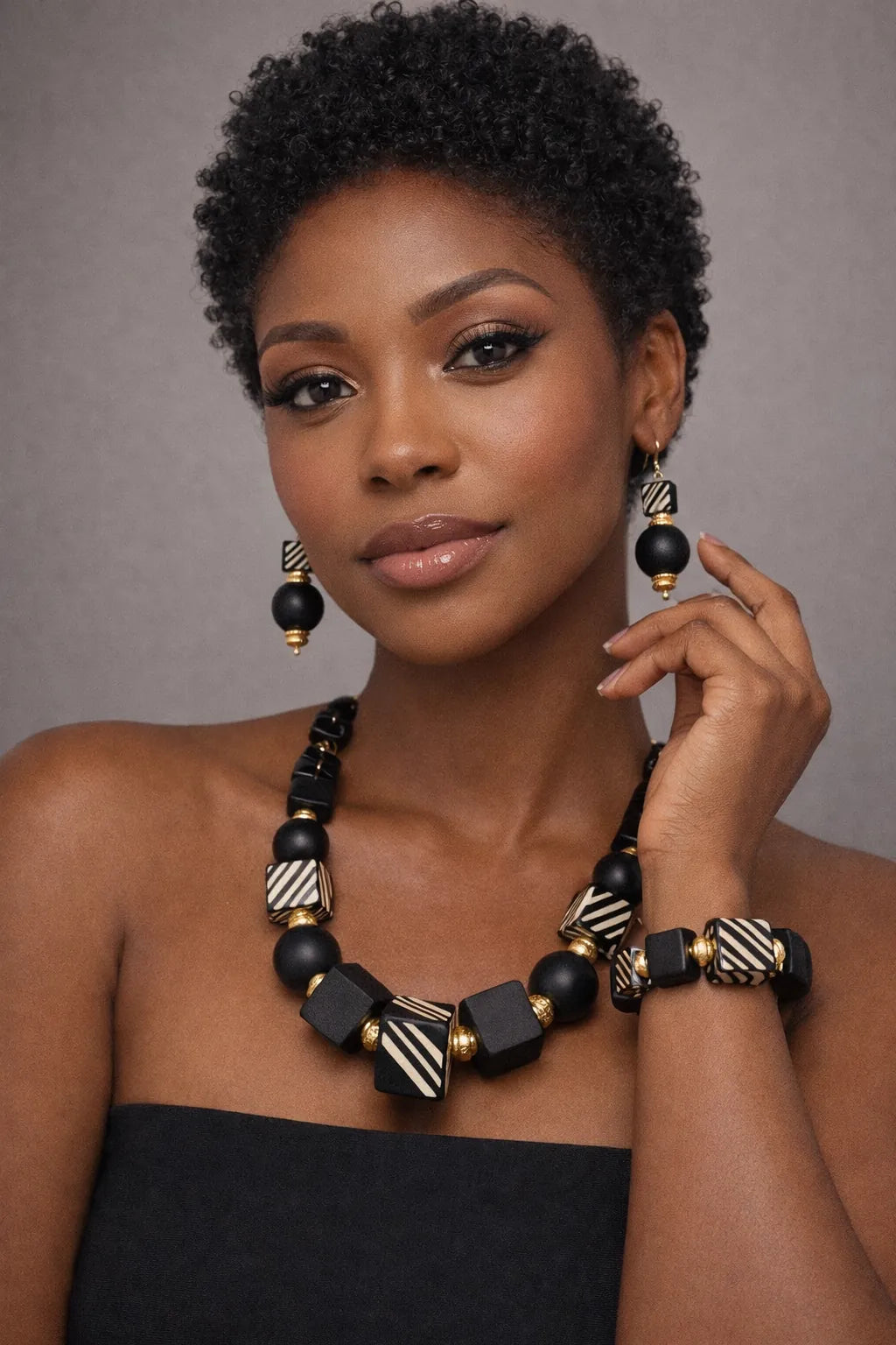 Brown skin model wearing bold black and gold Afrocentric statement necklace, earrings and bracelet set – Black Royalty Bead Set