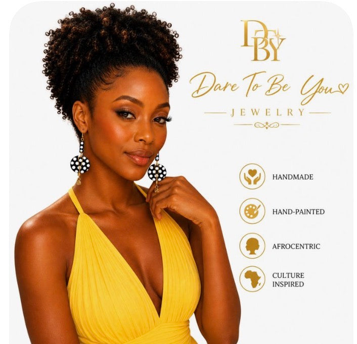 Sophisticated Black woman wearing handmade Afrocentric black and white polka statement earrings with gold accents on a clean white background by Dare To Be You Jewelry.