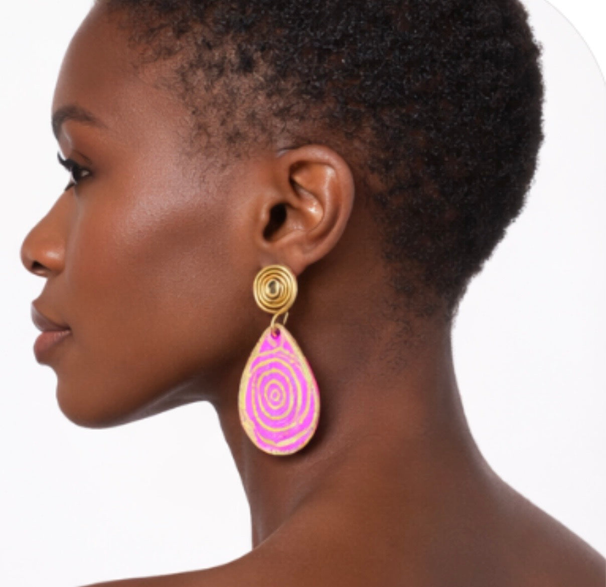 Side view of dark skin model wearing pink and gold afrocentric spiral earrings showing length and detail