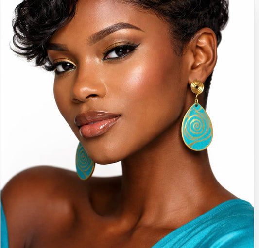 Dark skin woman with short wavy hair wearing turquoise and gold Afrocentric statement earrings