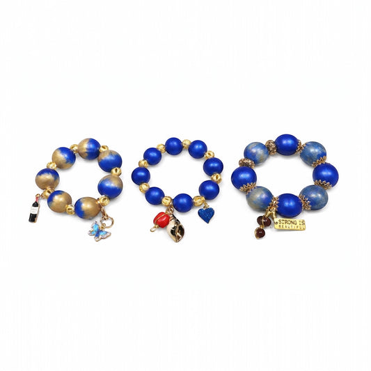 Chunky 25mm hand-painted wood bead bracelet trio in royal blue and gold shown as complete Afrocentric statement set with charm details