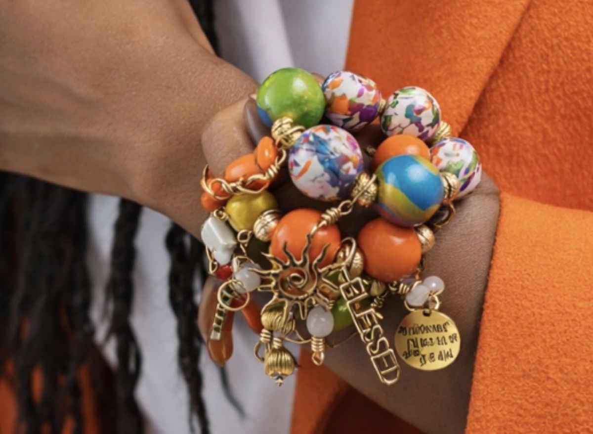 Handmade Afrocentric bracelet stack with inspirational charms worn on brown skin wrist