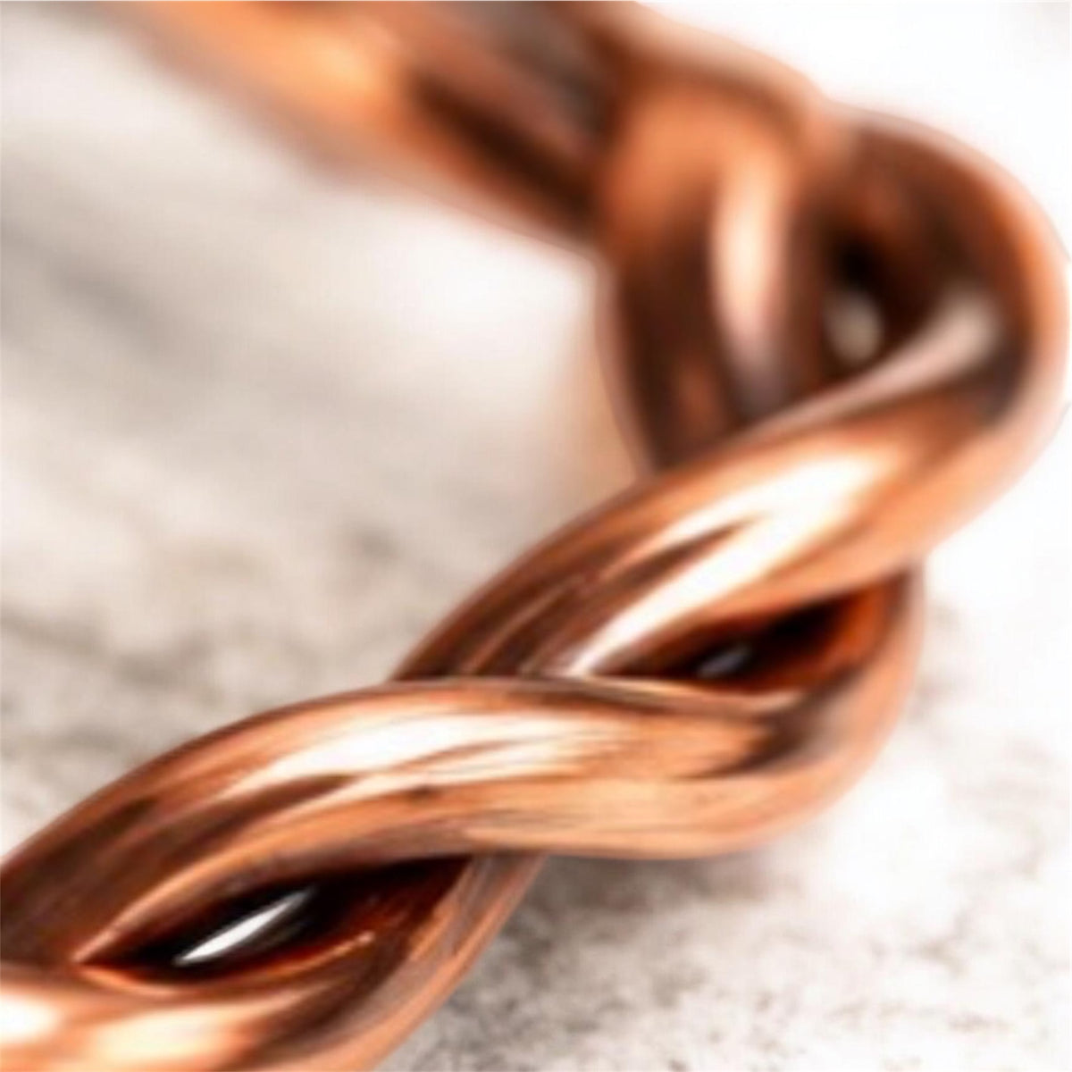 Close up of hand twisted pure copper bracelet with wrapped copper end detailing