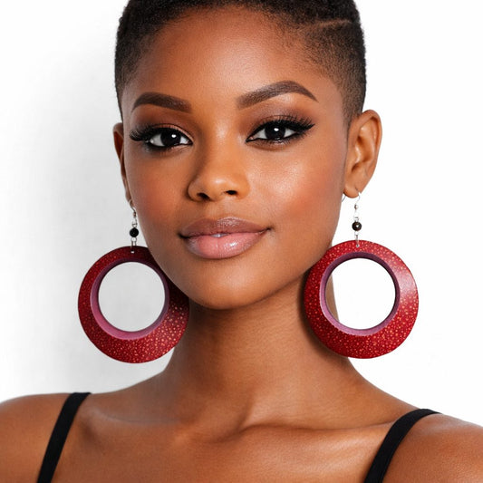 Brown skin woman facing forward wearing handmade red calabash statement earrings